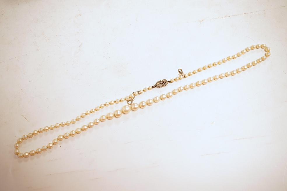 A cultured pearl and diamond necklace, early 20th century, composed of a single strand of graduated natural pearls measuring approximately 3.5-7.9cm, to a clasp set with a circular-cut diamond weighing approximately 0.07